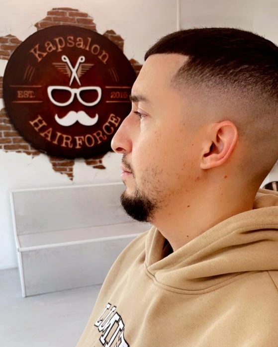 Hoge skin fade met strak bijgewerkte baardlijn